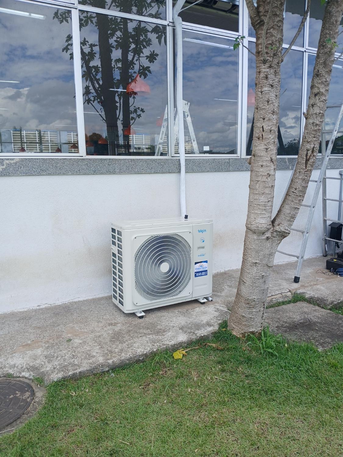 Condensadora Elgin inverter instalada na fachada com identificação Clima Certo